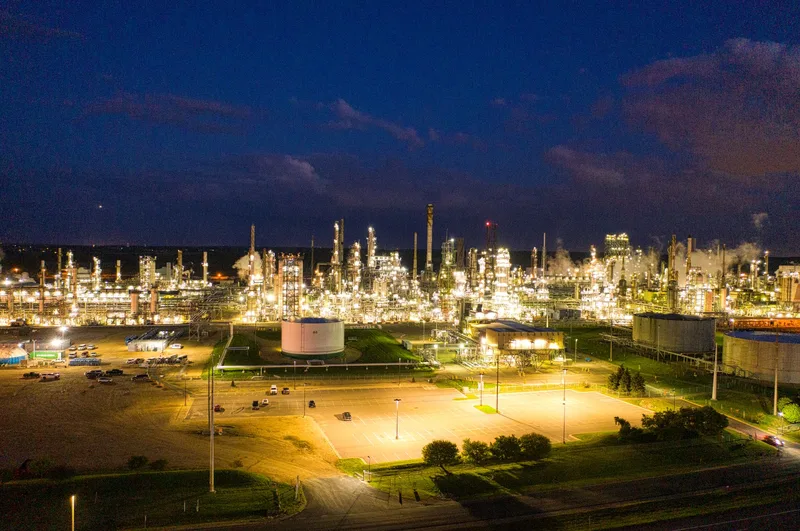 Gece aydınlatmasıyla bacaları ve tesisleriyle görülen bir petrokimya tesisi
