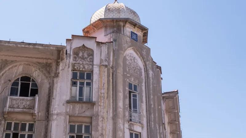 Yıpranmış cephesi ve kubbeli köşe kulesiyle restorasyon bekleyen tarihi bir bina
