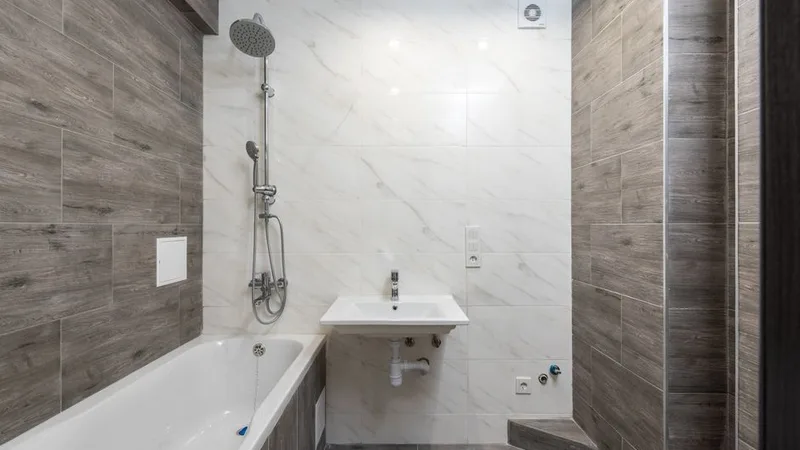 Yeni fayans döşenmiş ve armatürleri takılmış modern bir banyo