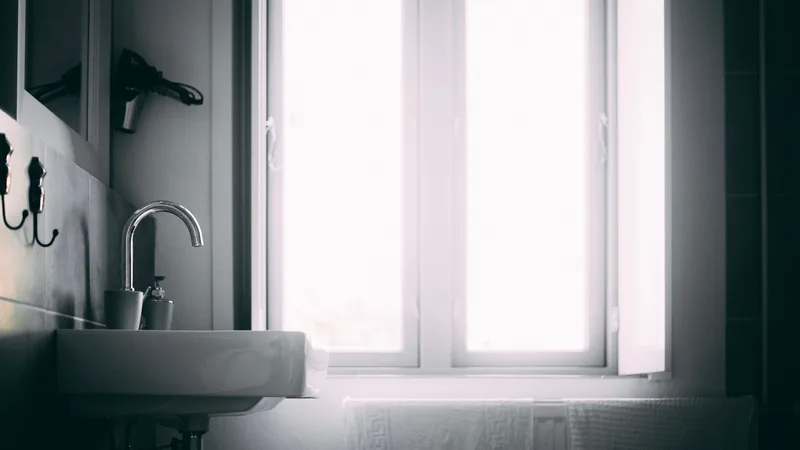 Doğal ışık alan, penceresi açık bir banyo lavabosu
