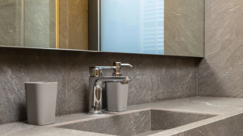 Taş kaplamalı lavabo ve krom batarya detayı