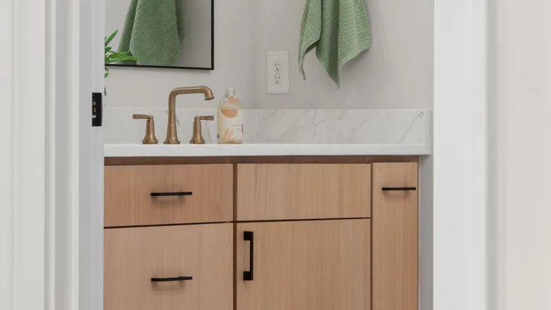 Ahşap dolaplı, mermer tezgahlı bir banyo lavabosu