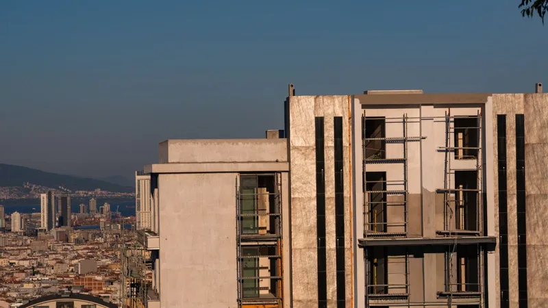 İzmir Körfezi kıyısında yükselen yeni kule binaların inşaatı, arkada şehir silüeti