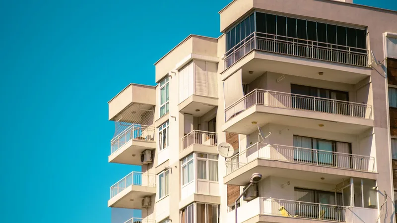 Bornova'da güneşli bir günde balkonlu, çok katlı bir apartman binasının cephesi