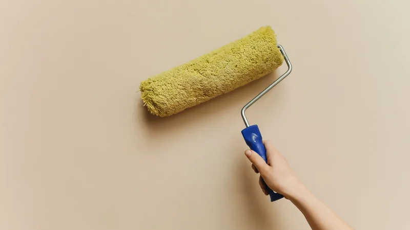 Sarı rulo ile boyanan bej renkli bir duvar