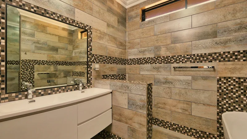 Mozaik fayans desenli, ayna ve lavabolu banyo iç mekanı