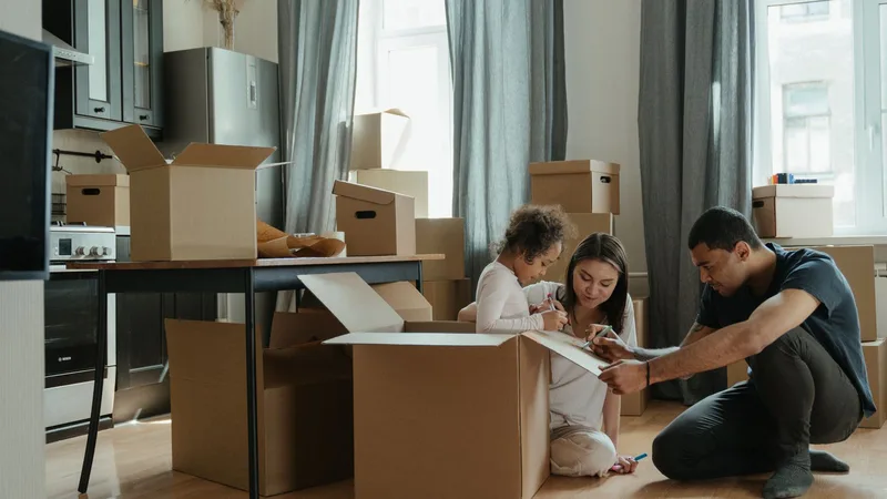 Yeni taşınılan bir evde birlikte kutu açan bir aile