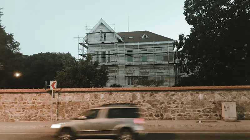 Akşam ışığında iskele kurulmuş, tadilat halindeki eski bir bina
