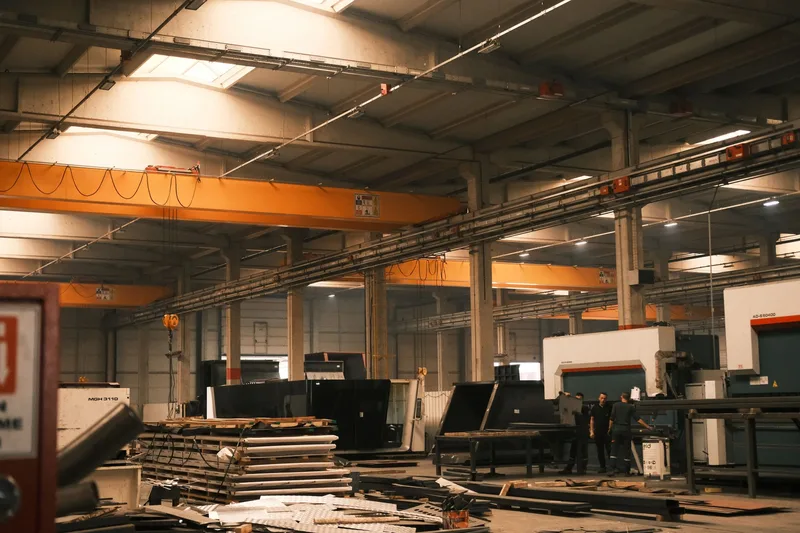 Metal işleme makineleri ve vinç raylarıyla donatılmış bir fabrika iç mekanı