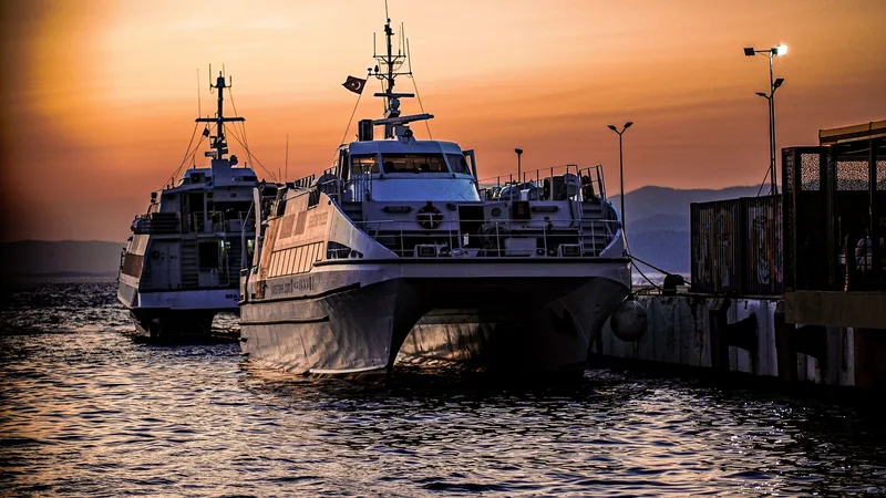 Gün batımında bir liman iskelesine yanaşan feribotlar