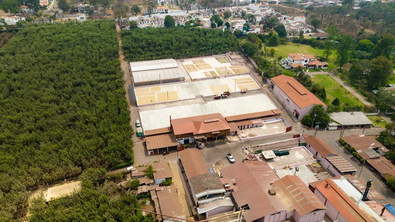 Yeşillikler arasında organize sanayi bölgesine ait geniş çatılı fabrika binalarının kuşbakışı görünümü