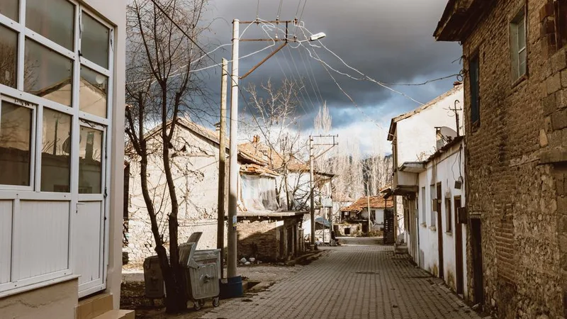Sokaktan görünen, kırmızı çatılı ve tuğla cepheli yoğun apartman binaları