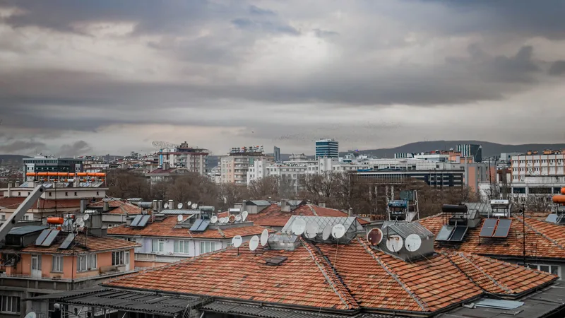 Kırmızı kiremit çatılı, güneş kolektörlü ve uydu antenli yoğun bir apartman dokusu
