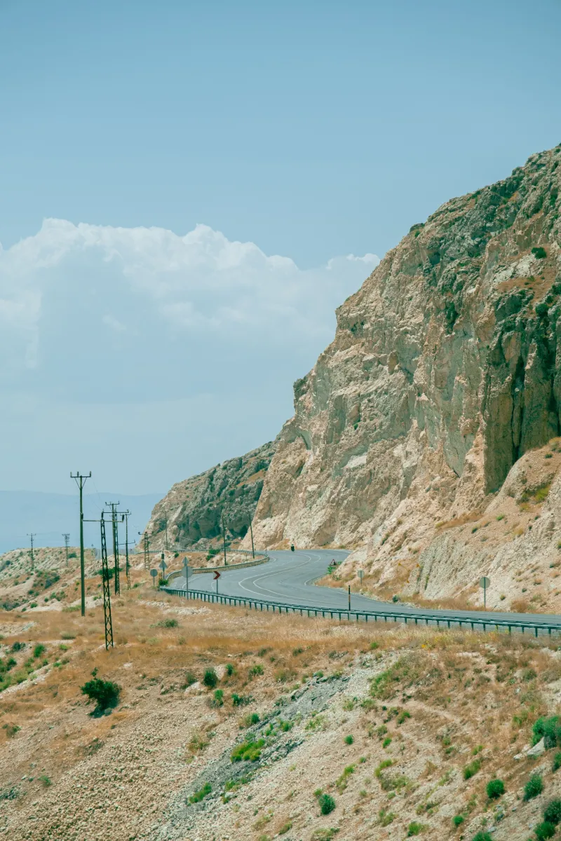 Dağlık bir yamaçtan geçen dar ve virajlı bir yol