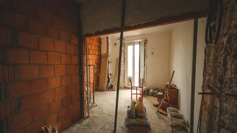 Tuğla duvarları görünen, yarı yenilenmiş bir oda