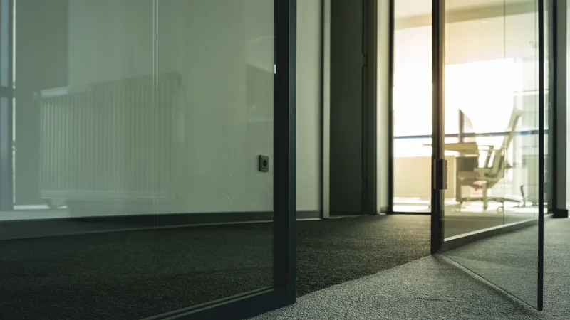 Cam kapılı, minimalist tasarımlı bir ofis koridoru