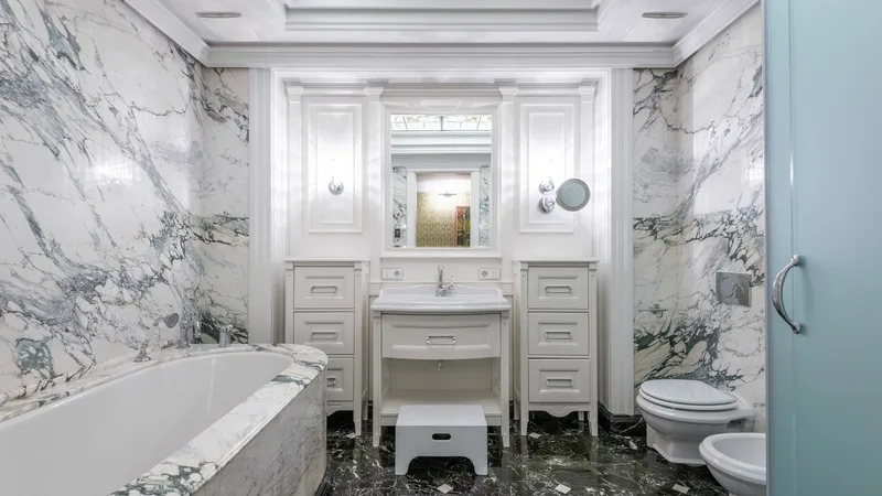 Mermer duvarlı, modern armatürlü bir banyo