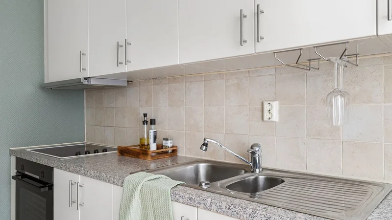 Granit tezgahlı, beyaz dolaplı sade bir mutfak