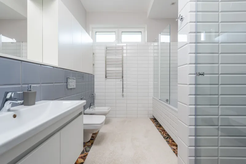 Duş kabini ve gri-beyaz fayanslarla yenilenmiş bir banyo