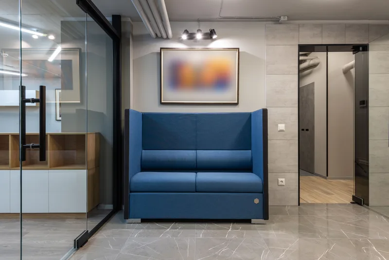 Mavi koltuklu, modern bir ofis bekleme/resepsiyon alanı