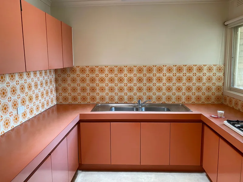 Turuncu tonlarda dolapları olan, eski tarz bir mutfak